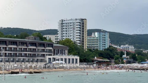People swimming and sunbathing on a crowded resort beach