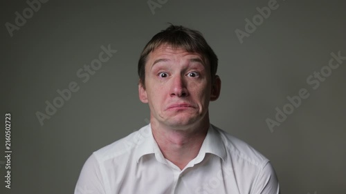 Businessman in a white t-shirt  with a sad and disappointed facial expression. Studio portrait isolated on a white background, suitable for business, stress andal concepts.