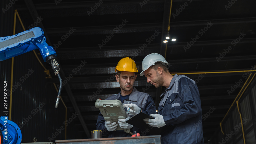 Manufacturing Engineers assessing industrial machinery During Machine Inspection and Robotics Maintenance in a Factory Scene 312