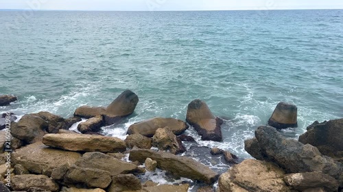 Rocky seashore with breakwater and waves