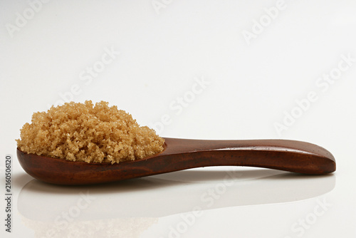 Fotografie Loose Brown Sugar on spoon close up on white background