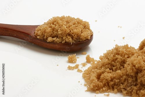 Foto Loose Brown Sugar on spoon close up on white background