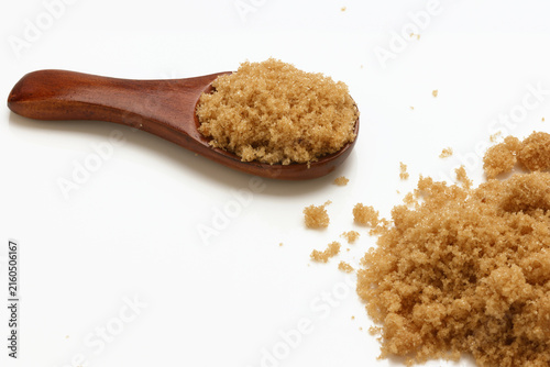 Loose Brown Sugar on spoon close up on white background