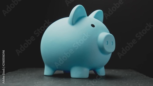Blue piggy bank from rotating on table. People may find it useful for saving coins. Financials savings. Close-up in 4K, UHD