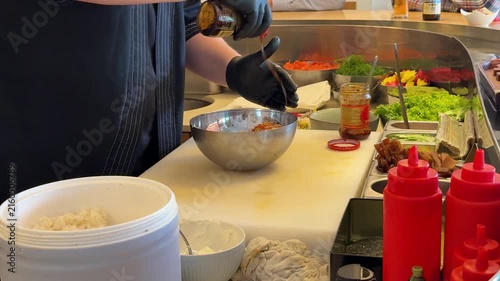 Chef drizzling sauce on salad, Japanese restaurant food preparation close up