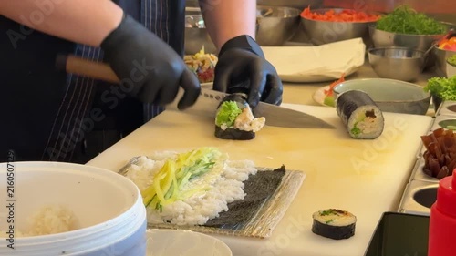 Sushi chef preparing rolls at counter, Japanese restaurant kitchen close up
