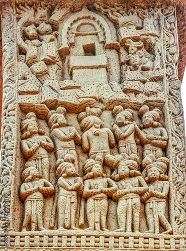 Aniconic Buddhist relief depicting the veneration of a sacred empty throne within a chaitya shrine, symbolizing the presence of the Buddha, surrounded by devotees and celestial beings, from Sanchi