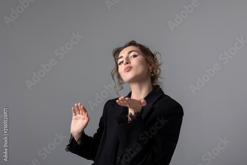 Foto Woman blowing a kiss with a playful expression in a studio setting