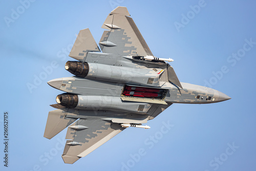 Bild auf Leinwand Stealth fighter jet banking with thrust vectoring and open weapons bay