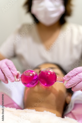 Client receiving facial cryo globes treatment