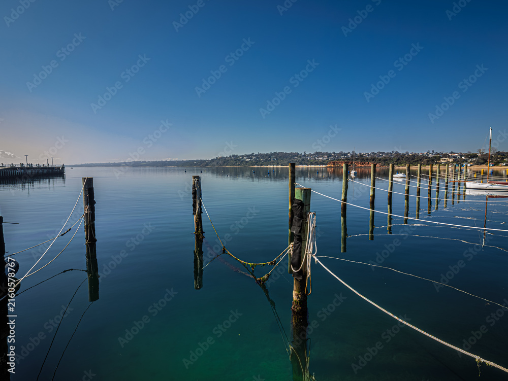 Fototapeta premium Pilings And Ropes Lead To Deserted Anchorage