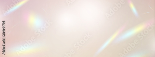 A soft beige and pink background with gentle, prismatic rainbow-colored rays of light and the backdrop