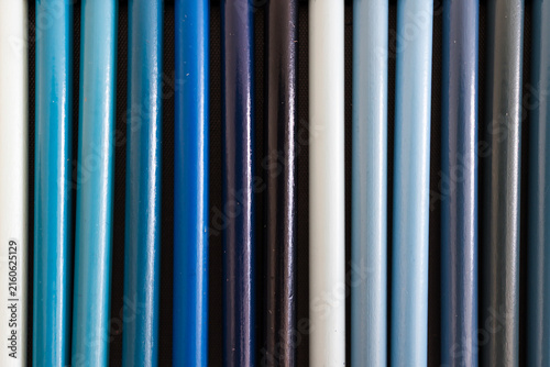 close-up of light and dark blue colored pencils neatly lined up in pencil case, concept of creativity, drawing, education and art supplies
