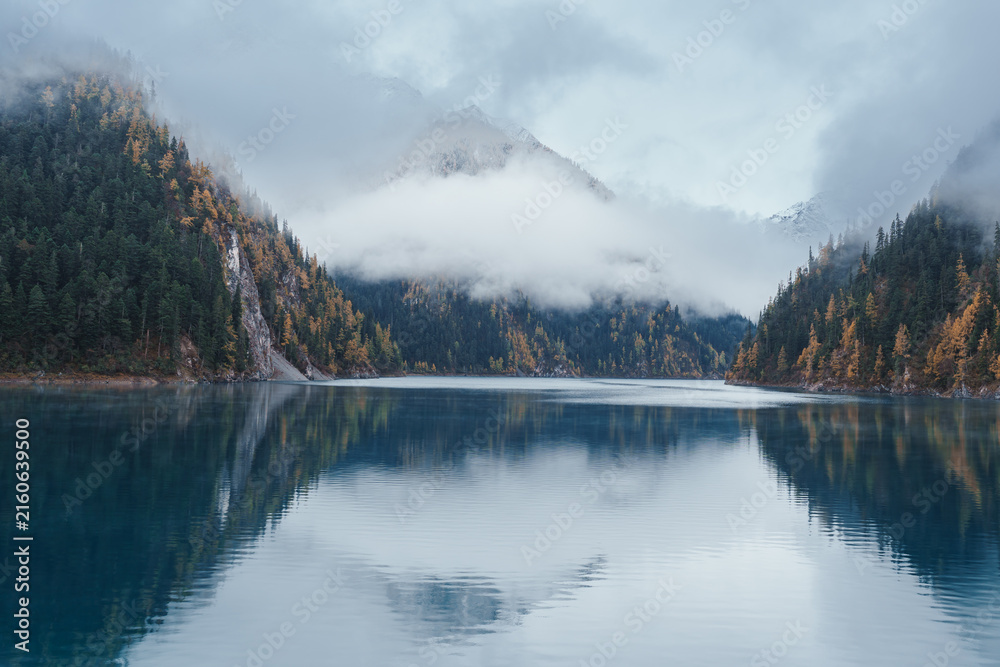 Fototapeta premium Scenery Jiuzhaigou national park in Sichuan, China. Beautiful Long lake and snow mountain in Autumn season. Famous Landmark and Vacation near Chengdu, China. Asia travel concept