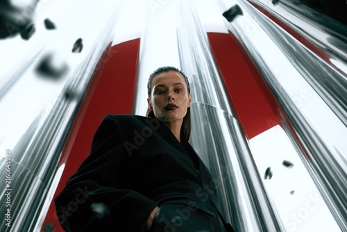 Futuristic Fashion Portrait: Woman in Black Blazer with Metallic Background