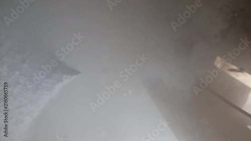 Cryogenic liquid nitrogen leak and dry ice sublimation producing dense cold vapor under heavy industrial machinery.