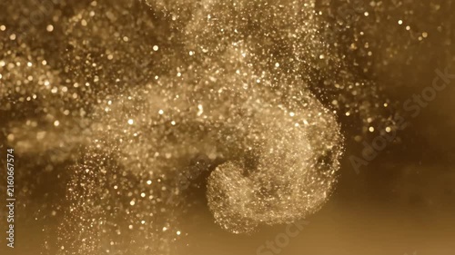 Golden particles swirling in soft light with dreamy bokeh glow