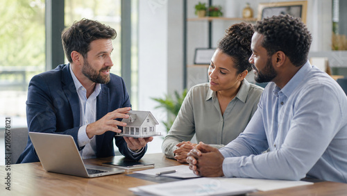 Real estate agent showing house model to clients