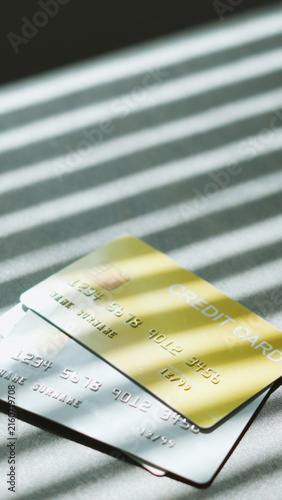 Online checkout, multiped credit card on desk with window shadow. financial business idea.