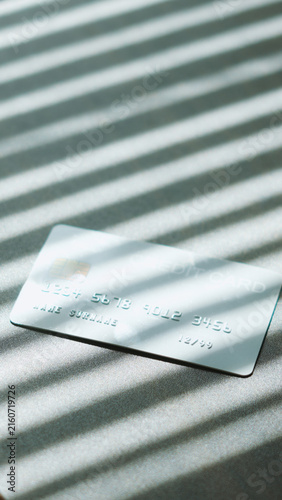 E-commerce checkout, Silver credit card with natural sunlight shadow effect for payment concept.