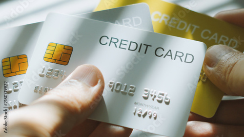 Smart financial decision, hands selecting silver credit card among multiple cards. shopping online concept.