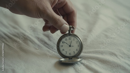 Vintage Pocket Watch Held by a Hand on Soft Textured Fabric Surface