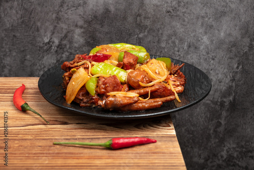 Spicy Stir Fried Chicken Feet with Peppers and Onion on Black Plate
