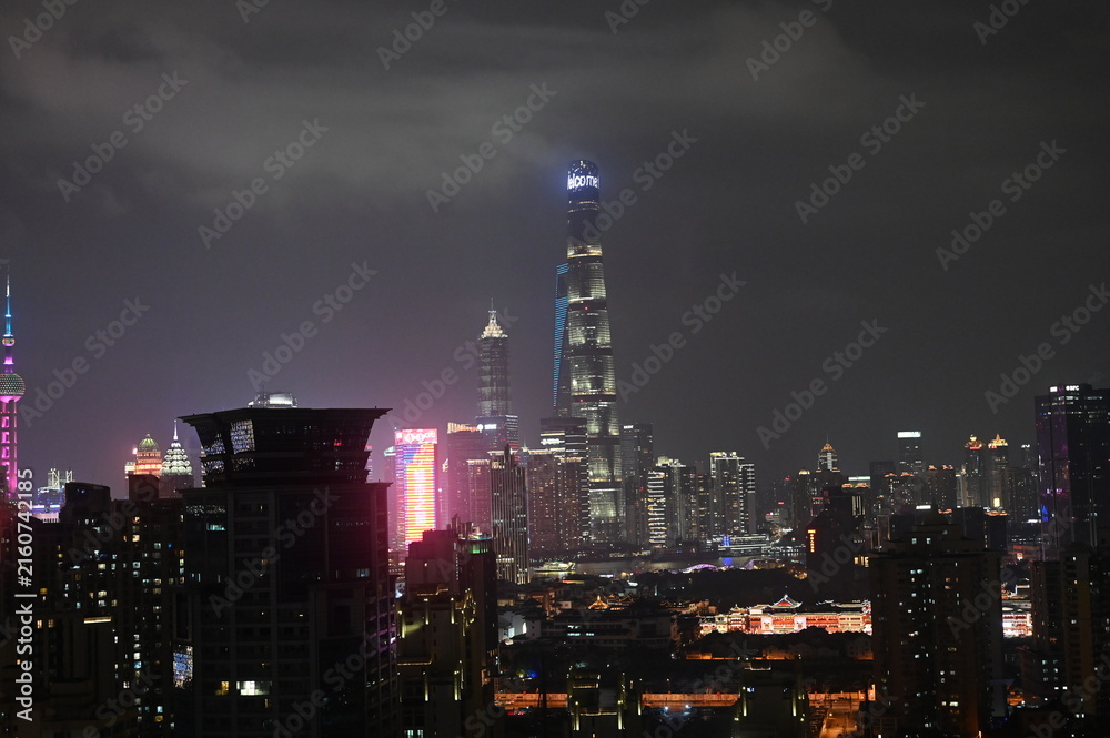 Fototapeta premium Night time view of the Shanghai city skyline - a panorama photo of the modern architecture and dense urban environment in the evening