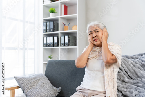 Cuadro en lienzo Senior woman suffering from severe ear pain or headache, covering her ears, feel