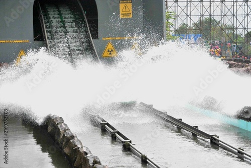Big splash water slide ride at amusement park, thrilling log flume attraction with massive water spray, fun theme park adventure