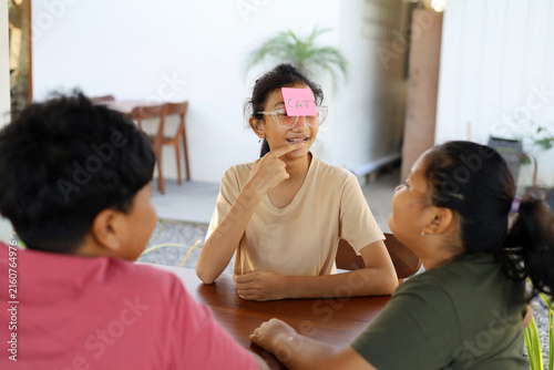 Photography Children play the guessing game Who am I?, with paper stickers on their foreheads