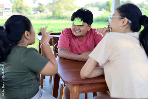Photography Children play the guessing game Who am I?, with paper stickers on their foreheads