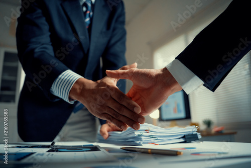 Business people closing a deal with a firm handshake in a modern office, symbolizing trust, agreement, and cooperation
