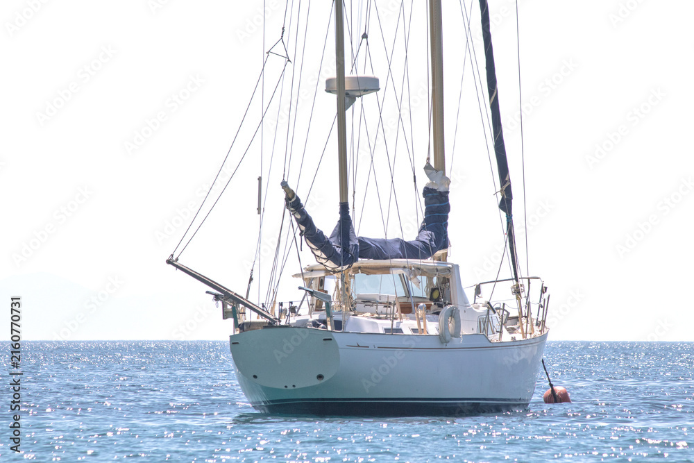Obraz premium Sailboat lay at anchor offshore. Luxury yacht concept. Boat on sea or ocean. Ship or marine vessel..