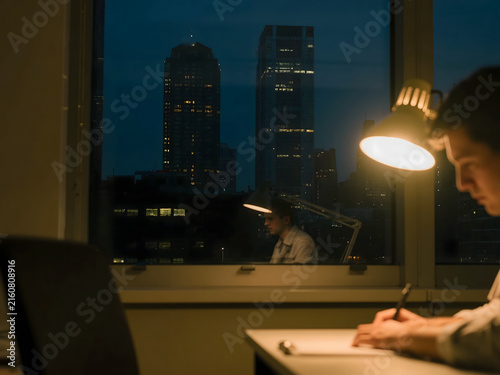 Focused Night Work by City Window