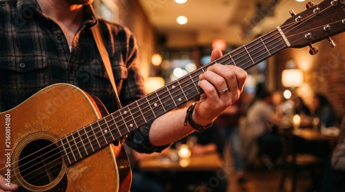 Musician playing acoustic guitar shot, live performance in cozy restaurant or cafe, musician hand on fretboard, entertainment and leisure, warm ambient lighting atmosphere