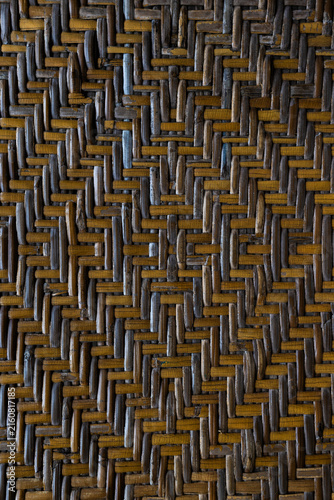 Intricate woven bamboo pattern with geometric diamond design and natural warm brown tones creating a textured background