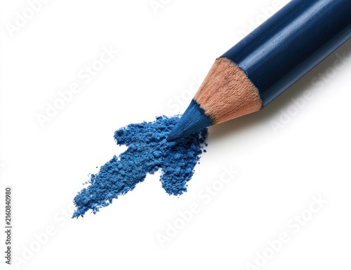 A sharpened dark blue cosmetic pencil creates a vibrant blue powder trail