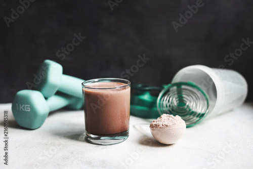 Cuadro en lienzo Chocolate protein shake glass with whey protein powder scoop, fitness dumbbells