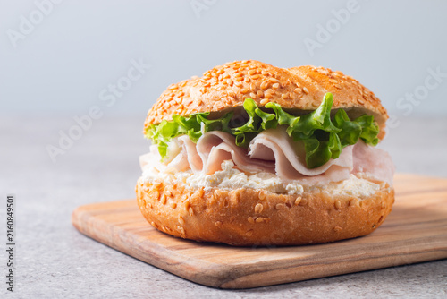 Sesame bagel sandwiches with turkey and chicken ham, cream cheese and fresh lettuce. Healthy food bun burger concept.