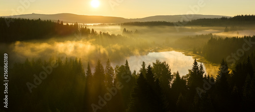 Fotografía Golden sunrise over misty forest and lake in Northern Bohemia, Czech Republic