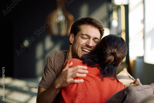 Quadro su tela Affectionate couple having fun while embracing at home.