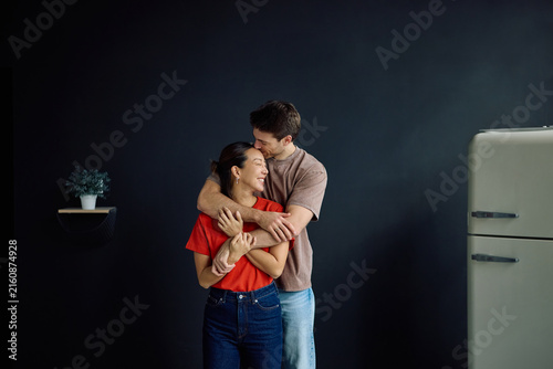 Quadro su tela Affectionate multiracial couple embracing at home.