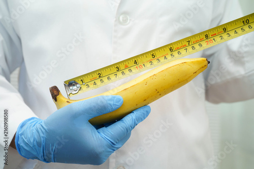 Quadro su tela Male doctor stands holding a banana, penis health.