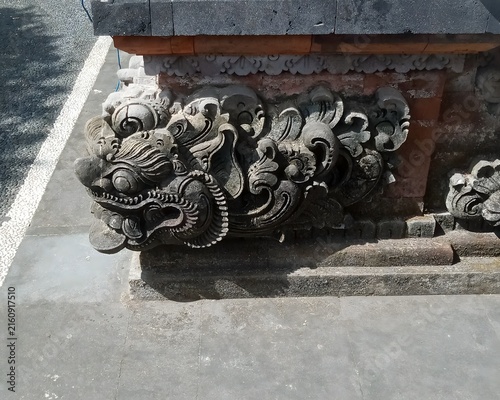 Картината върху платно Detailed traditional Balinese stone carving of dragon ornament on temple foundat