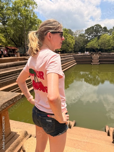 Bild auf Leinwand Femme observant un ancien bassin en pierre sur un site historique du Sri Lanka