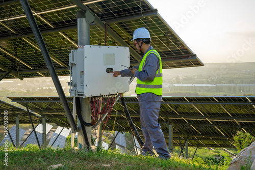 Bild auf Leinwand Worker inspecting solar power system equipment outdoors