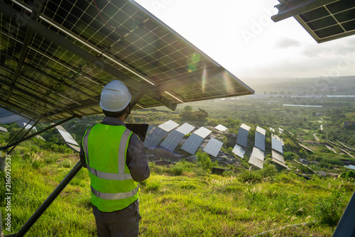 Принти на полотні Engineer inspecting solar power plant with laptop on hillside