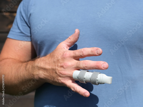 Fotografía Worker in protective workwear showing injured finger with splint after workplace