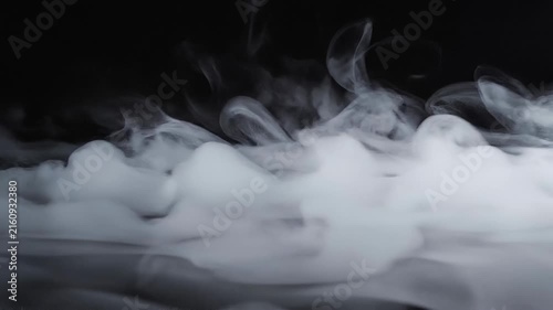Abstract white smoke swirling on black background with mist fog effect